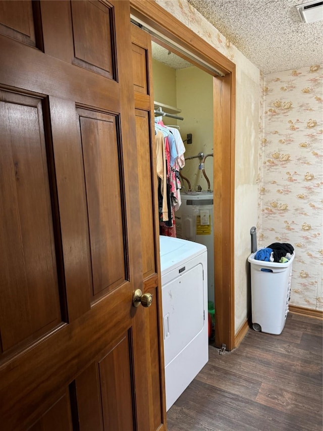 laundry room featuring a textured ceiling, washer / dryer, and dark hardwood / wood-style flooring