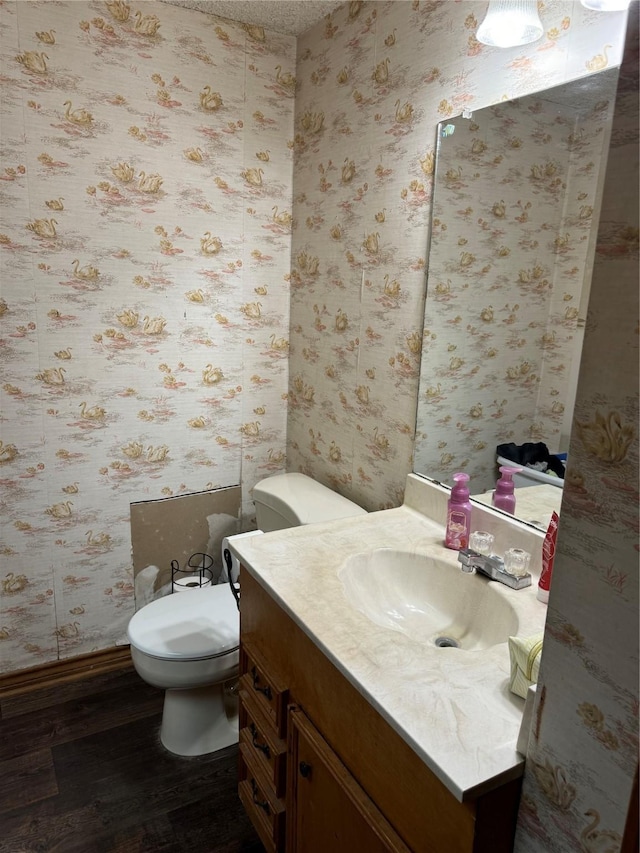 bathroom with hardwood / wood-style floors, toilet, and vanity