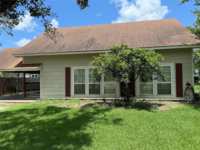 rear view of house featuring a yard