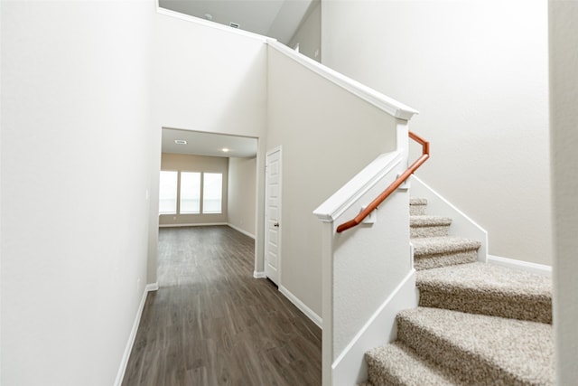 stairs with a high ceiling and wood-type flooring