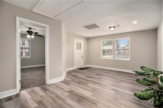 empty room with a textured ceiling, hardwood / wood-style flooring, and ceiling fan