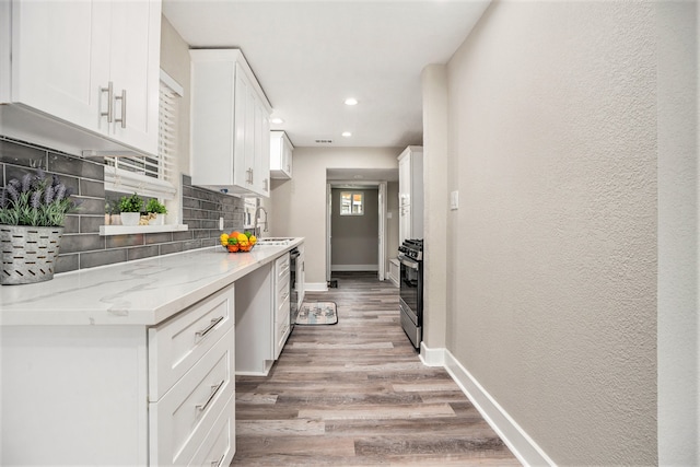 kitchen with white cabinets, backsplash, and light stone counters