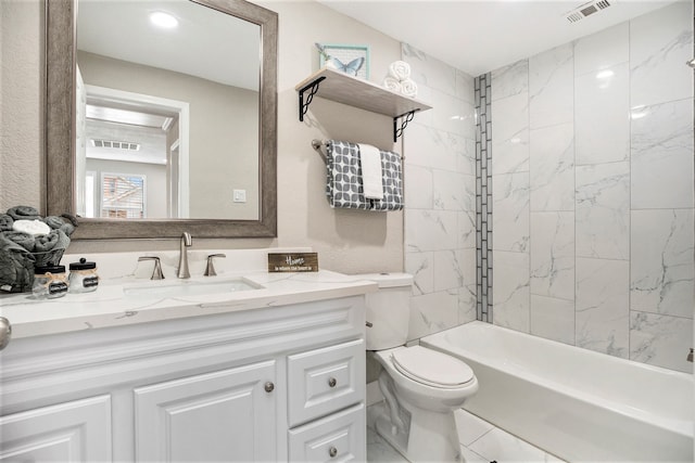 full bathroom featuring tiled shower / bath combo, vanity, and toilet