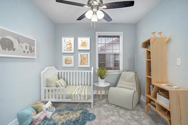 sitting room with ceiling fan and carpet