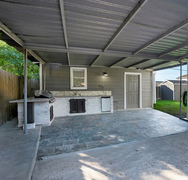 view of patio with sink, a storage unit, and grilling area