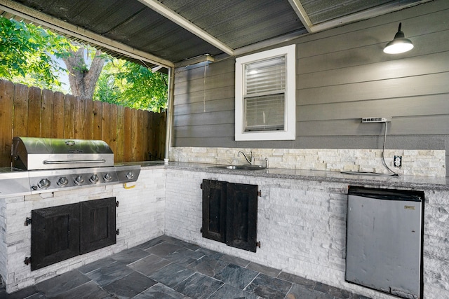 view of patio / terrace featuring grilling area, an outdoor kitchen, and sink