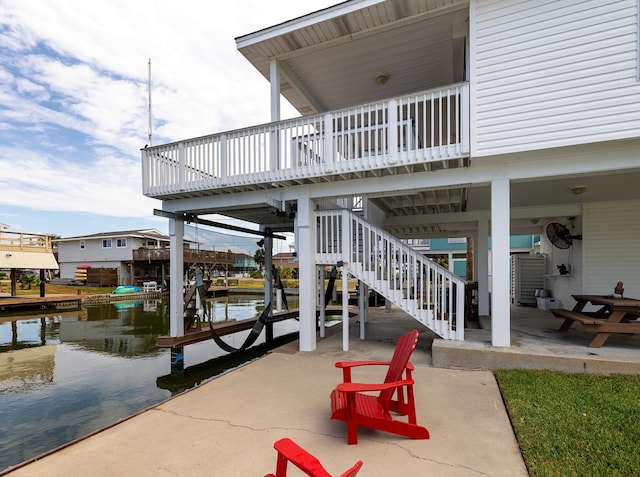 view of patio with a boat dock and a water view