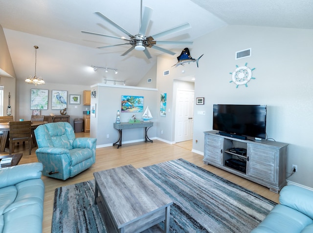 living room featuring ceiling fan with notable chandelier, rail lighting, light wood-type flooring, and high vaulted ceiling