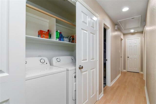 clothes washing area featuring light hardwood / wood-style flooring and washer and dryer