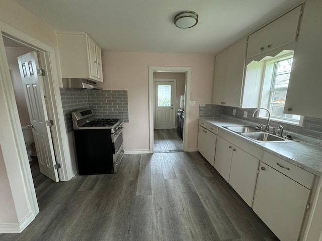 kitchen with stainless steel gas stove, sink, white cabinets, and tasteful backsplash