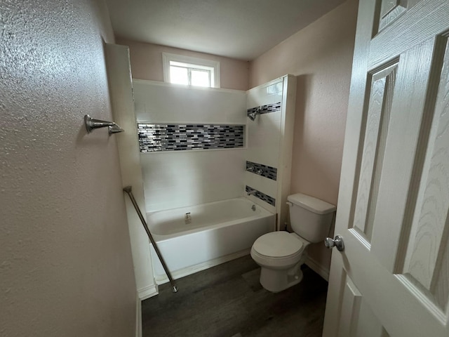 bathroom with toilet and tiled shower / bath