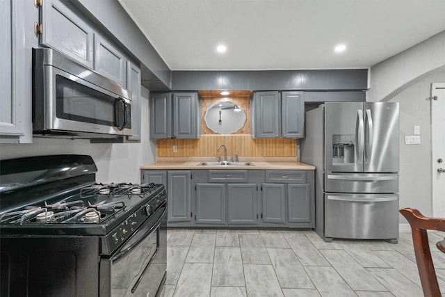 kitchen featuring appliances with stainless steel finishes, sink, and gray cabinetry