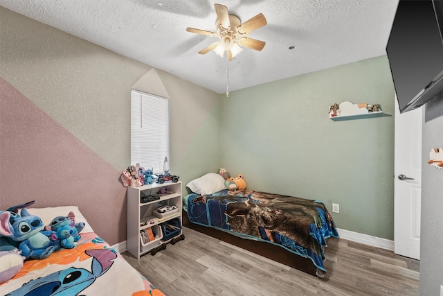 bedroom featuring a textured ceiling, light hardwood / wood-style flooring, and ceiling fan