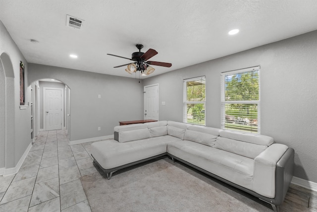 tiled living room with ceiling fan