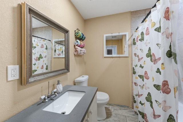 bathroom featuring vanity, tile patterned flooring, and toilet