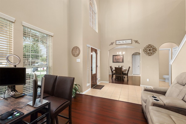 home office featuring a towering ceiling and tile patterned floors