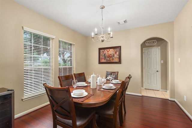 dining space with hardwood / wood-style flooring and an inviting chandelier