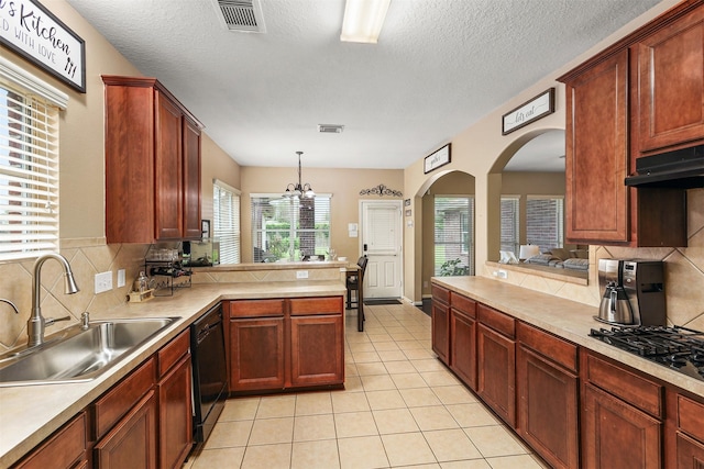 kitchen with sink, black appliances, kitchen peninsula, pendant lighting, and backsplash