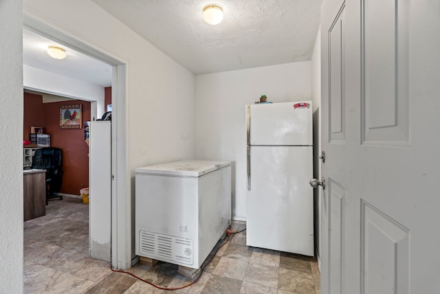 laundry room with light tile patterned flooring and a textured ceiling