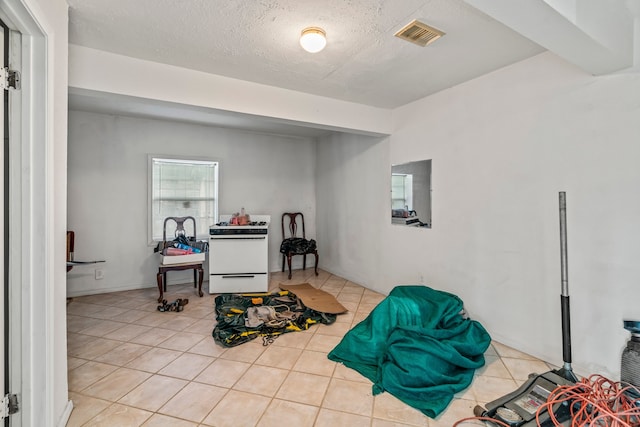 interior space with light tile patterned floors and a textured ceiling