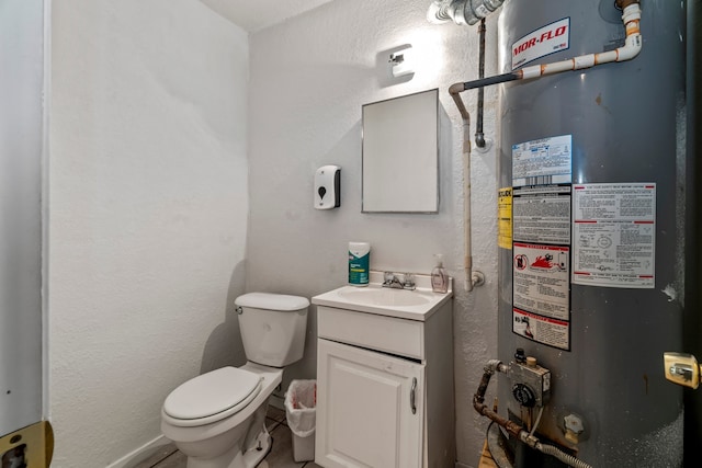 bathroom featuring tile patterned flooring, toilet, vanity, and water heater