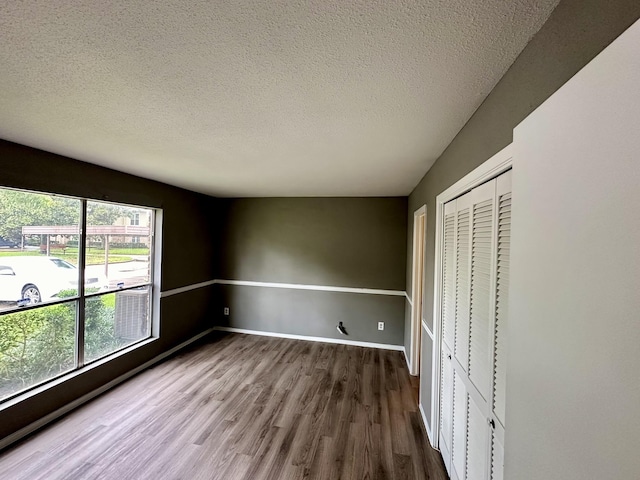 unfurnished bedroom with hardwood / wood-style flooring, a textured ceiling, and a closet