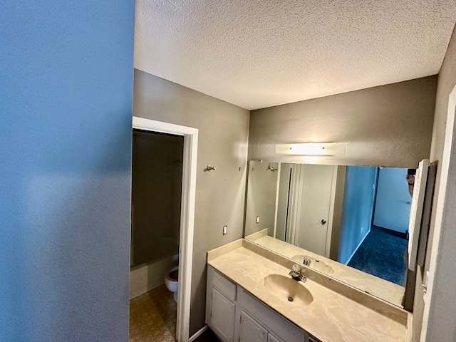 bathroom featuring toilet, vanity, and a textured ceiling