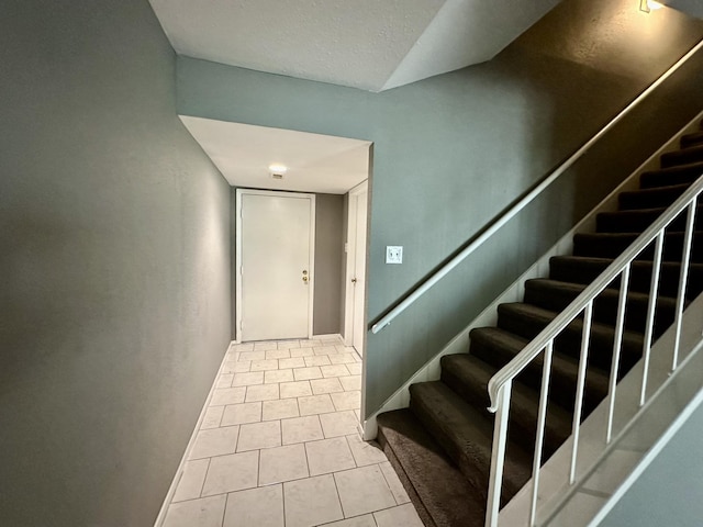 stairway with tile patterned floors