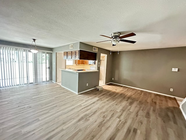 unfurnished living room with light hardwood / wood-style flooring, a textured ceiling, and ceiling fan