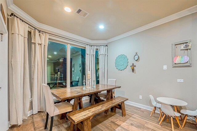 dining room featuring light wood-type flooring and ornamental molding