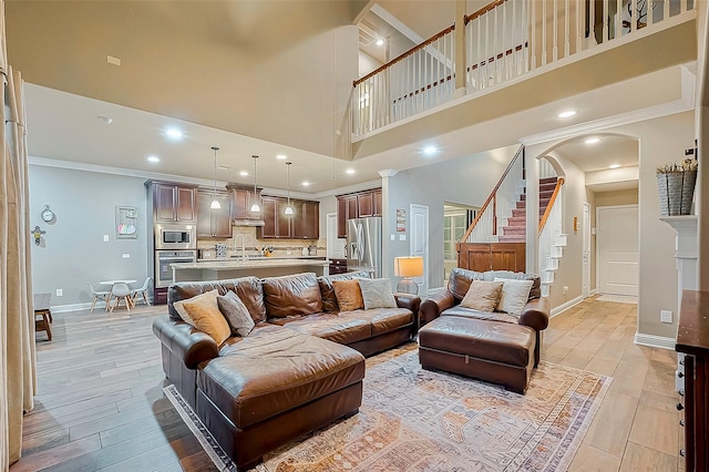 living room with ornamental molding and a high ceiling