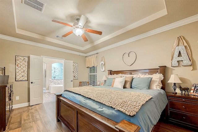 bedroom with ceiling fan, light hardwood / wood-style floors, crown molding, and a tray ceiling