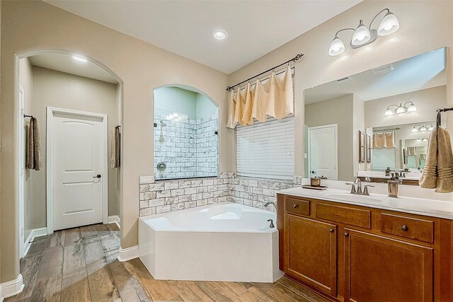 bathroom with a tub, vanity, and hardwood / wood-style flooring