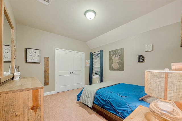 bedroom featuring vaulted ceiling, a closet, and carpet flooring