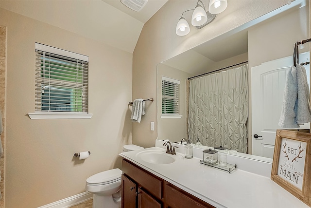 bathroom featuring vaulted ceiling, vanity, a wealth of natural light, and toilet