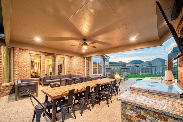 view of patio / terrace featuring sink, ceiling fan, exterior kitchen, and an outdoor hangout area