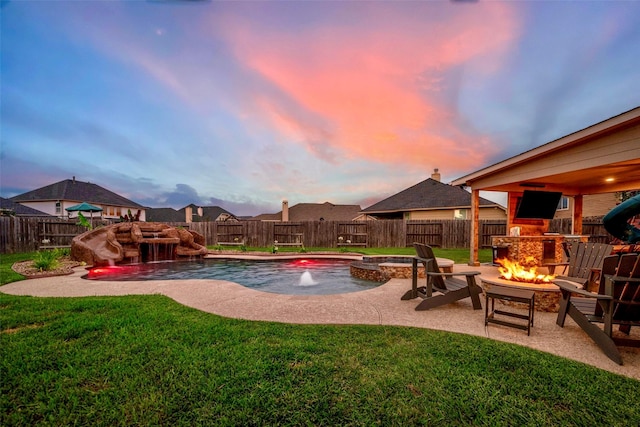 pool at dusk with a patio, pool water feature, a lawn, and a fire pit