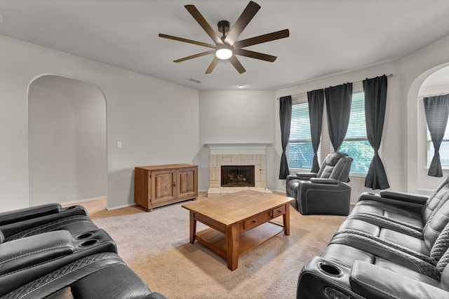 carpeted living room with a fireplace and ceiling fan