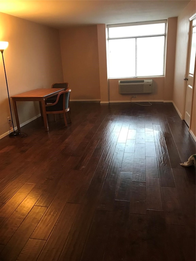 empty room featuring a wall mounted air conditioner and dark hardwood / wood-style floors