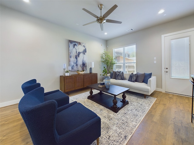 living room featuring light hardwood / wood-style floors and ceiling fan