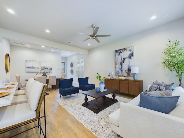 living room featuring ceiling fan and light hardwood / wood-style flooring