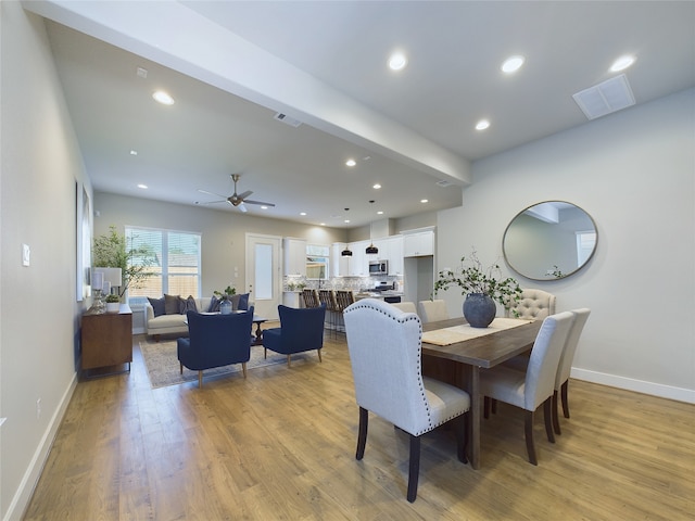 dining area with light wood-type flooring and ceiling fan