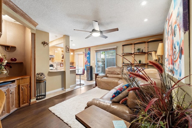 living room with a textured ceiling, dark hardwood / wood-style floors, and ceiling fan