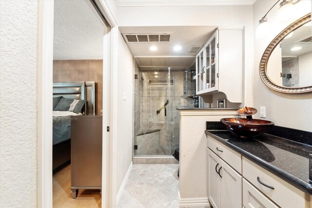 bathroom with vanity, a textured ceiling, and walk in shower