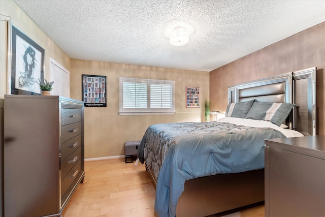 bedroom with light wood-type flooring and a textured ceiling