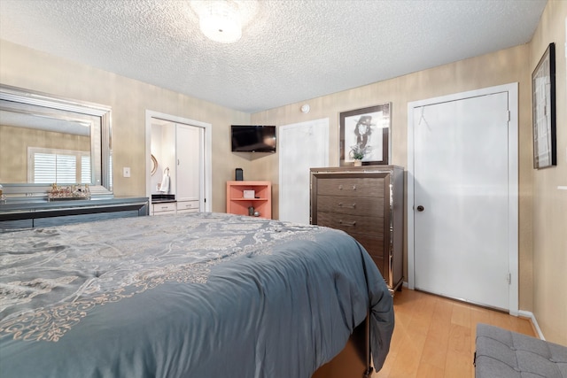 bedroom with light hardwood / wood-style floors and a textured ceiling