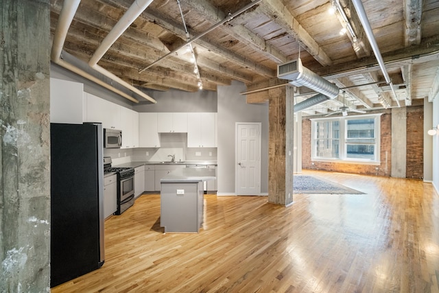 kitchen featuring light hardwood / wood-style flooring, white cabinets, a center island, appliances with stainless steel finishes, and sink