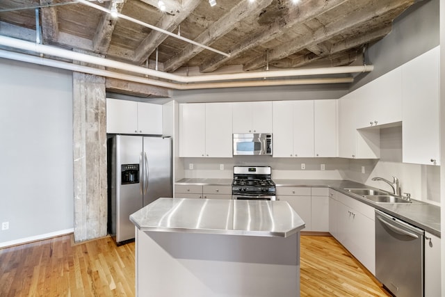 kitchen with stainless steel counters, white cabinetry, light hardwood / wood-style floors, appliances with stainless steel finishes, and sink