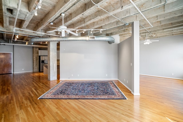 basement featuring wood-type flooring and ceiling fan