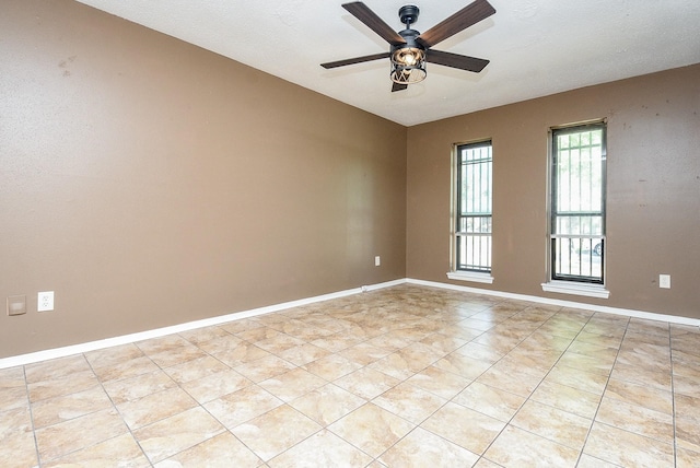 unfurnished room with light tile patterned flooring and ceiling fan